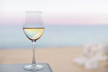 A glass of white wine on the sea beach