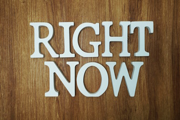 Right Now Word alphabet letters on wooden background