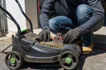 Obraz premium man repairing an electric lawn mower