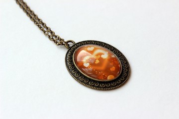 bronze pendant with a picture of hearts under glass
