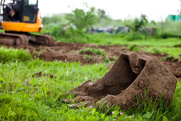 The excavator levels the earth on the site