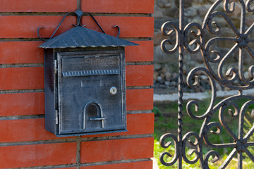 Vintage mailbox on brick wall outdoors. Soft focus.