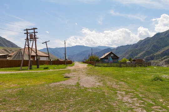 Rural lodges in Altai mountains. Car road. Summer sunny day.