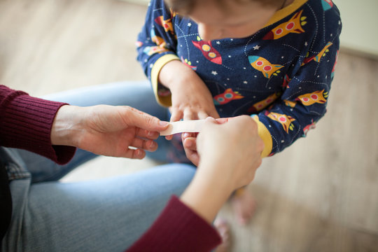 Woman sticks a band-aid son cut finger