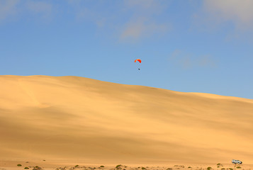 the sport of jumping from the sand dune and performing acrobatic maneuvers in the air during free...