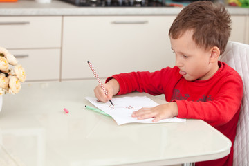 Inspired by the boy draws a picture on the paper at the table