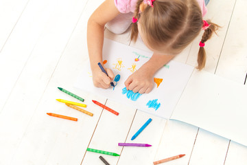 the girl draws with crayons in the album