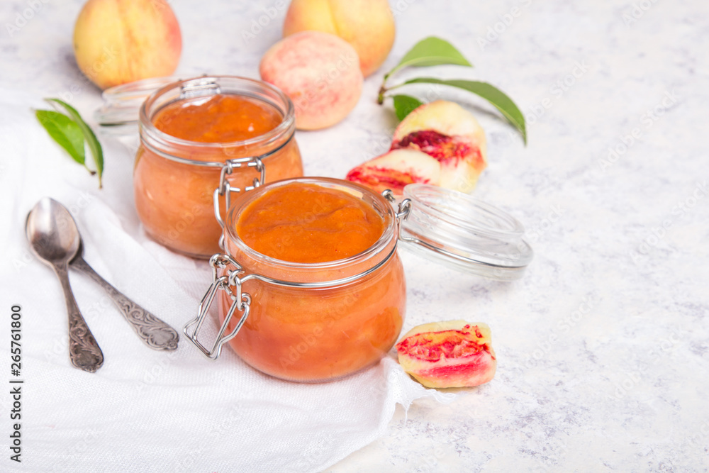 Wall mural Homemade peach jam with organic fruit. Sweet preserves on a light background