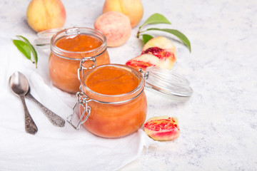 Homemade peach jam with organic fruit. Sweet preserves on a light background