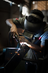 Worker wearing a protective mask welding metal