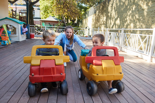 Zwei Jungs fahren im Tretauto im Kindergarten