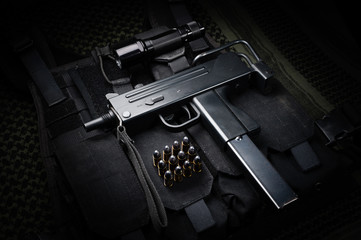 Submachine gun and 9mm round laid on a tactical vest