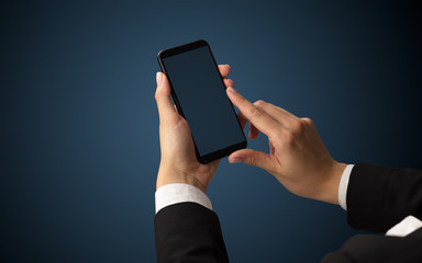 Mockup for female hand using frameless smartphone with dark background
