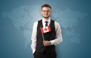 Cheerful businessman standing in front of a map with flag on his hand
