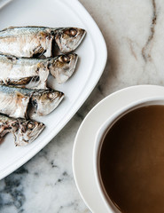 Grilled mackerel fishes with herbal soup top view