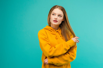 Obraz premium Portrait of a young woman looking at copy space isolated over bright blue background