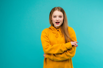 Obraz premium Portrait of an excited young woman isolated over bright blue background
