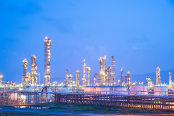 Oil refineries and oil depots and close-up of pipelines and destillation tanks of an oil-refinery plant in the evening