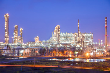 Fototapeta na wymiar Oil refineries and oil depots and close-up of pipelines and destillation tanks of an oil-refinery plant in the evening