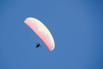 parachute flying in the sky with skies in a cloudless day