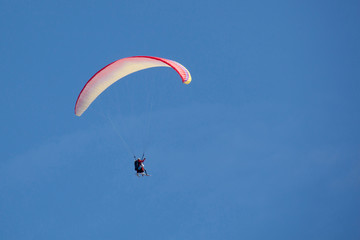 parachute flying side with skies in a cloudless day