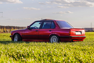 The rear of the old, red, German car that stands on the grass