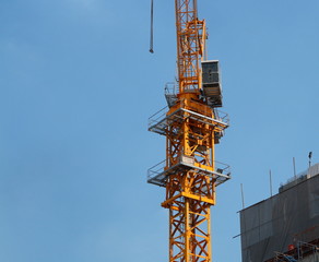 Fototapeta na wymiar A crane stands near a building under construction