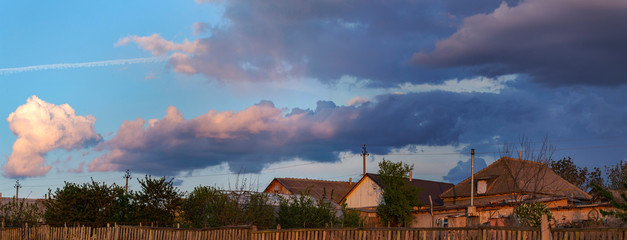 Obraz premium Landscape at sunset. Tragic gloomy sky. The village in the Budjak steppe in the spring. The terrain in southern Europe. It's springtime.