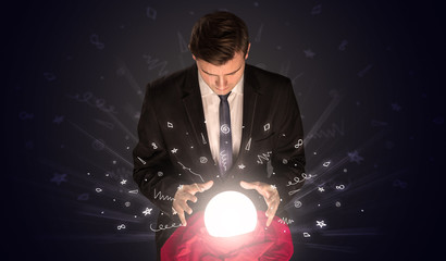 Gorgeous businessman looking to inspiration in a magic ball in his lap and doodle concept
