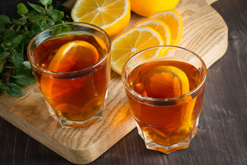 Glasses of cold ice tea with lemon, ice, mint on background. Homemade lemonade. Spring and summer drinks and beverages concept. 