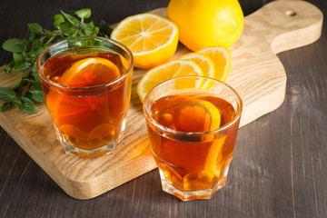 Glasses of cold ice tea with lemon, ice, mint on background. Homemade lemonade. Spring and summer drinks and beverages concept. 