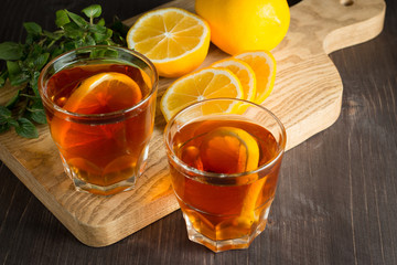 Glasses of cold ice tea with lemon, ice, mint on background. Homemade lemonade. Spring and summer drinks and beverages concept. 