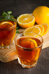 Glasses of cold ice tea with lemon, ice, mint on background. Homemade lemonade. Spring and summer drinks and beverages concept. 