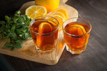 Glasses of cold ice tea with lemon, ice, mint on background. Homemade lemonade. Spring and summer drinks and beverages concept. 