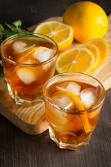 Glasses of cold ice tea with lemon, ice, mint on background. Homemade lemonade. Spring and summer drinks and beverages concept. 