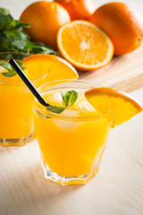 Photo of fresh orange juice in the glass jar. Summer healthy organic drink concept. Cold beverages with ice and orange fruits.