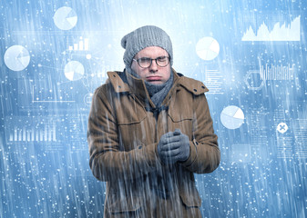 Young businessman shivering with graphs, reports and chart concept
