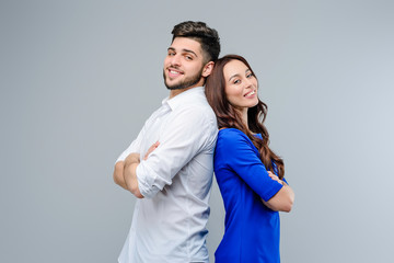 Happy and smiling young couple of man and woman isolated over grey background