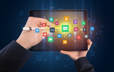 Hand using tablet with colorful bounce application symbols and icons concept
