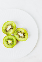 Three halves of ripe kiwi on a white  background. Top view, copy space