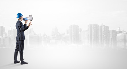 Young supervisor architect standing and looking at a big city panorama
