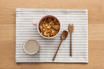 cereal with soy milk on the fabric mat, wood table for breakfast.