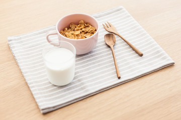 cereal with milk on the fabric mat, wood table for breakfast.
