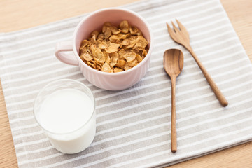 cereal with milk on the fabric mat, wood table for breakfast.