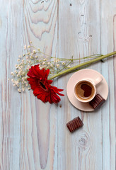 A cup of coffee, candy and gerbera
