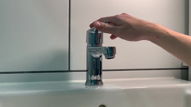 Front shot of drinkable water consumption concept. Ultra slowmotion of opening the water tab in bathroom. Not taking care of the water consumption.