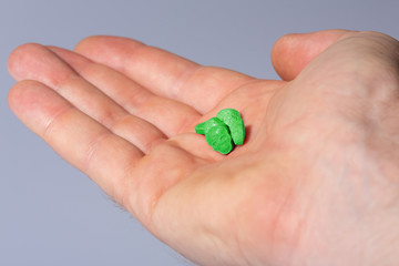 A caucasian handpalm with green MDMA, Amphetamine, Army Skull, Ecstasy or XTC pills.