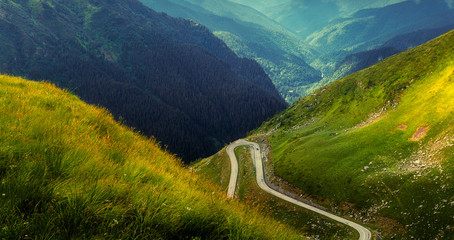 Wonderful Alpine highland under sunlight. caskade of mountains hills with road at sunset. impressively beautiful nature background.  Travel  is a Lifestyle, conception.