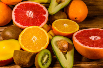 Still life with exotic fruits. Mango, oranges, avocado, grapefruit and kiwi fruits on wooden table