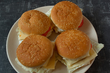 Four homemade burgers on a plate top view